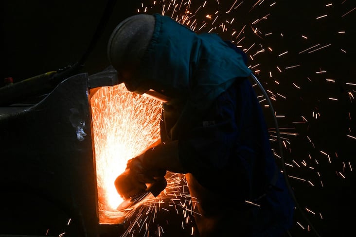 A worker grinds a a piece at the Hachette and Driout (AHD) foundry in Saint-Dizier on March 3, 2025. AHD, in receivership since December, have been taken over by the French company ACI Groupe. (Photo by FRANCOIS NASCIMBENI / AFP)